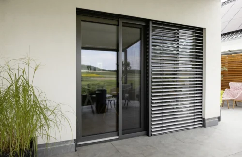 Moderne Terrassenverglasung mit Sonnenschutz und stilvoller Einrichtung